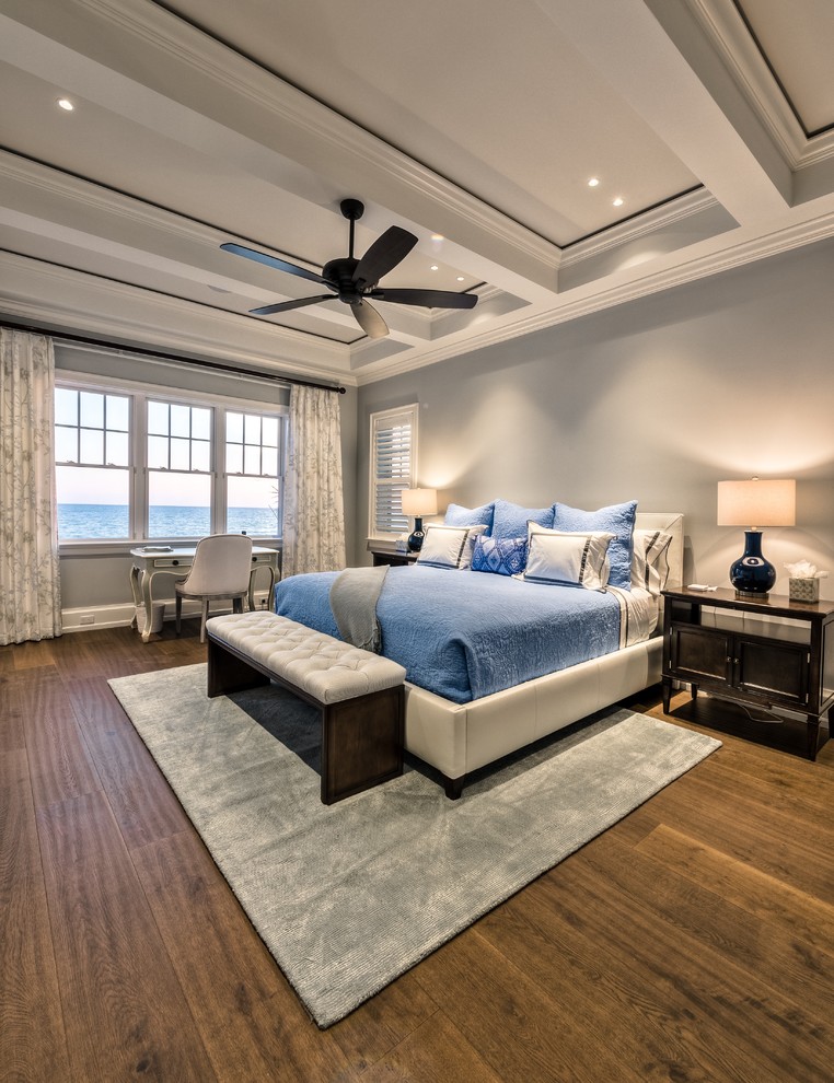 Expansive beach style master bedroom in Miami with medium hardwood floors.