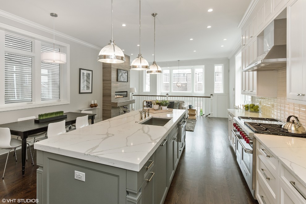 Design ideas for a large transitional single-wall open plan kitchen in Chicago with an undermount sink, shaker cabinets, white cabinets, quartz benchtops, white splashback, subway tile splashback, stainless steel appliances, dark hardwood floors and with island.