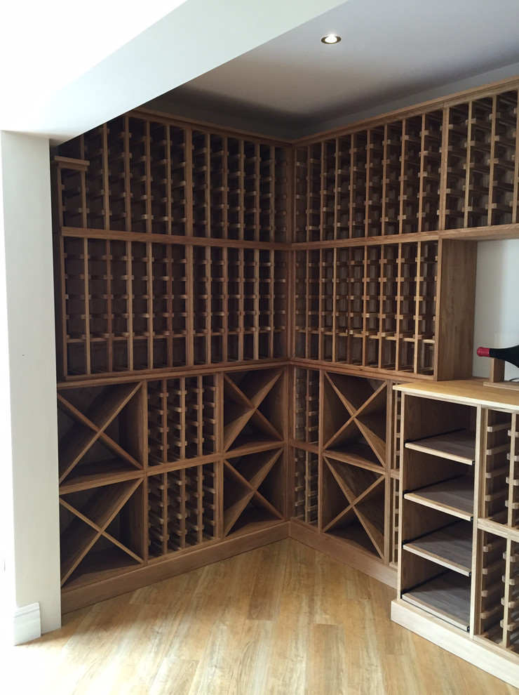 Photo of a large contemporary wine cellar in Other with storage racks, light hardwood floors and brown floor.