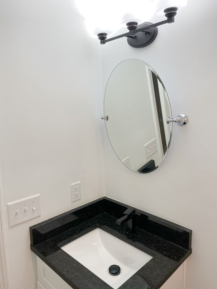 Example of a small trendy single-sink bathroom design in Atlanta with shaker cabinets, white cabinets, granite countertops, black countertops and a built-in vanity