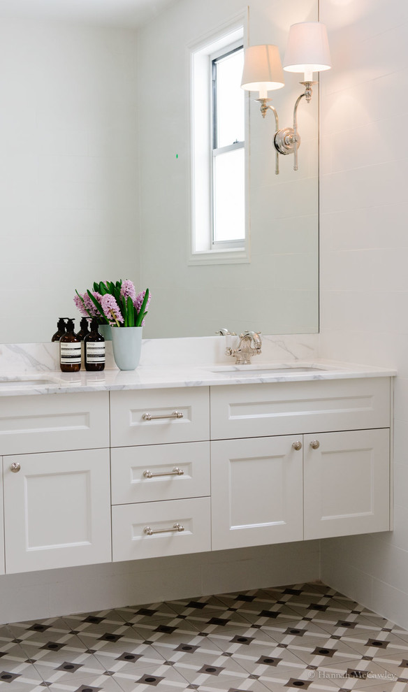 Inspiration for a large transitional master bathroom in Brisbane with recessed-panel cabinets, white cabinets, white tile, ceramic tile, white walls, ceramic floors, an undermount sink and marble benchtops.