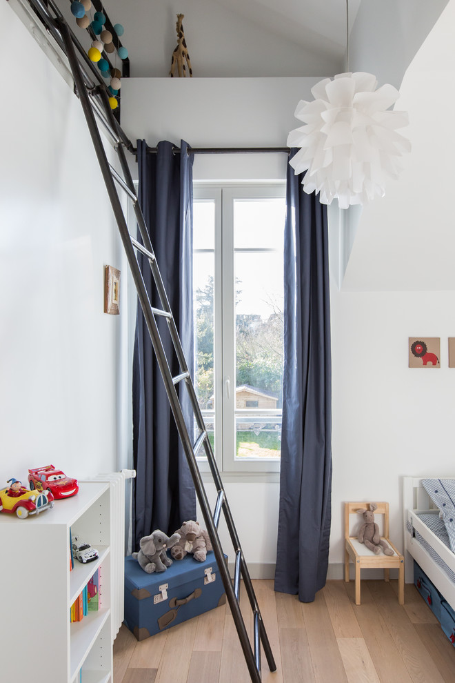 Réalisation d'une petite chambre neutre de 1 à 3 ans design avec un mur blanc et parquet clair.