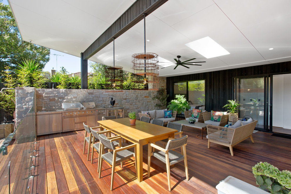 Large contemporary courtyard patio in Melbourne with an outdoor kitchen, decking and an awning.