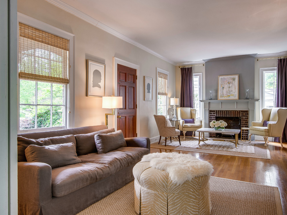 This is an example of a traditional living room in Charlotte with beige walls and a brick fireplace surround.