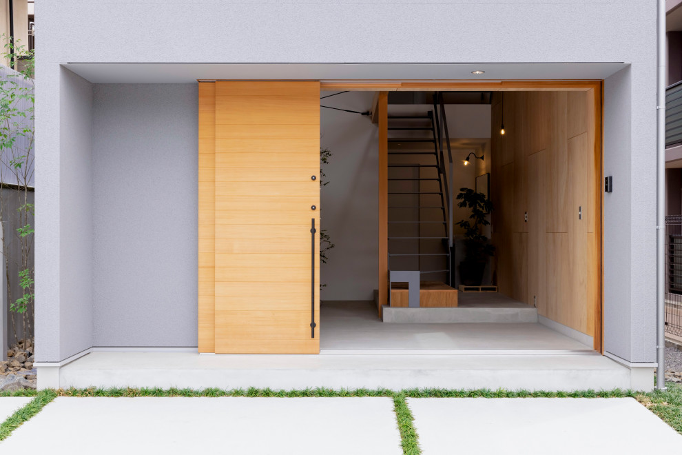 Mittelgroßes, Dreistöckiges Asiatisches Einfamilienhaus mit Mix-Fassade, grauer Fassadenfarbe, Satteldach, Blechdach, schwarzem Dach und Schindeln in Kyoto