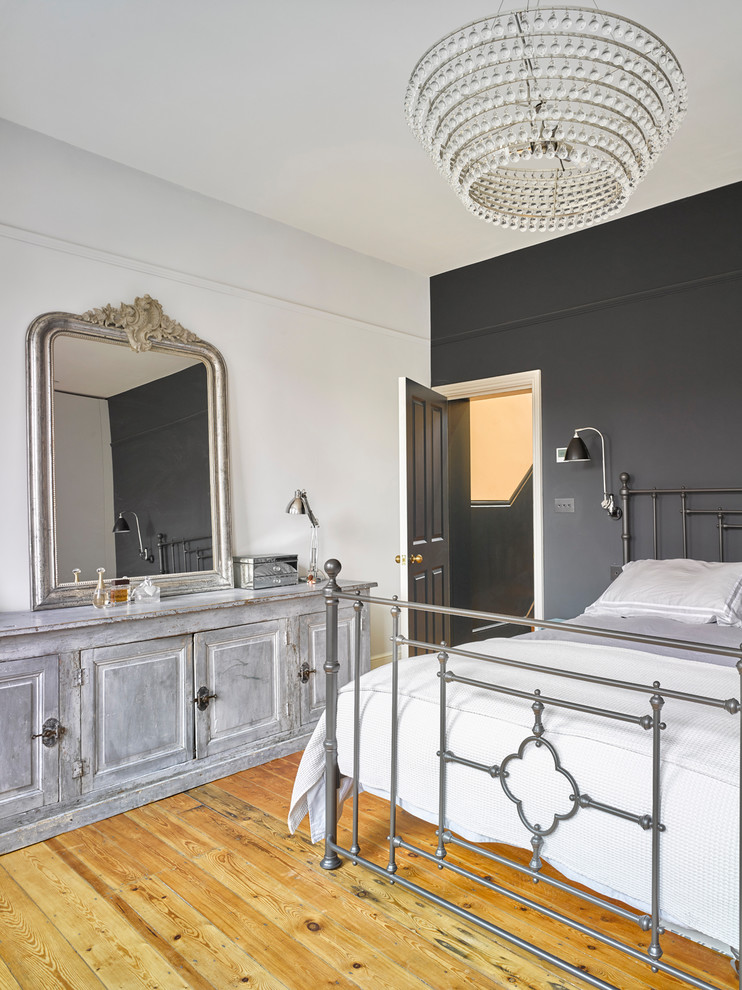 Design ideas for a master bedroom in London with light hardwood floors, beige floor and grey walls.