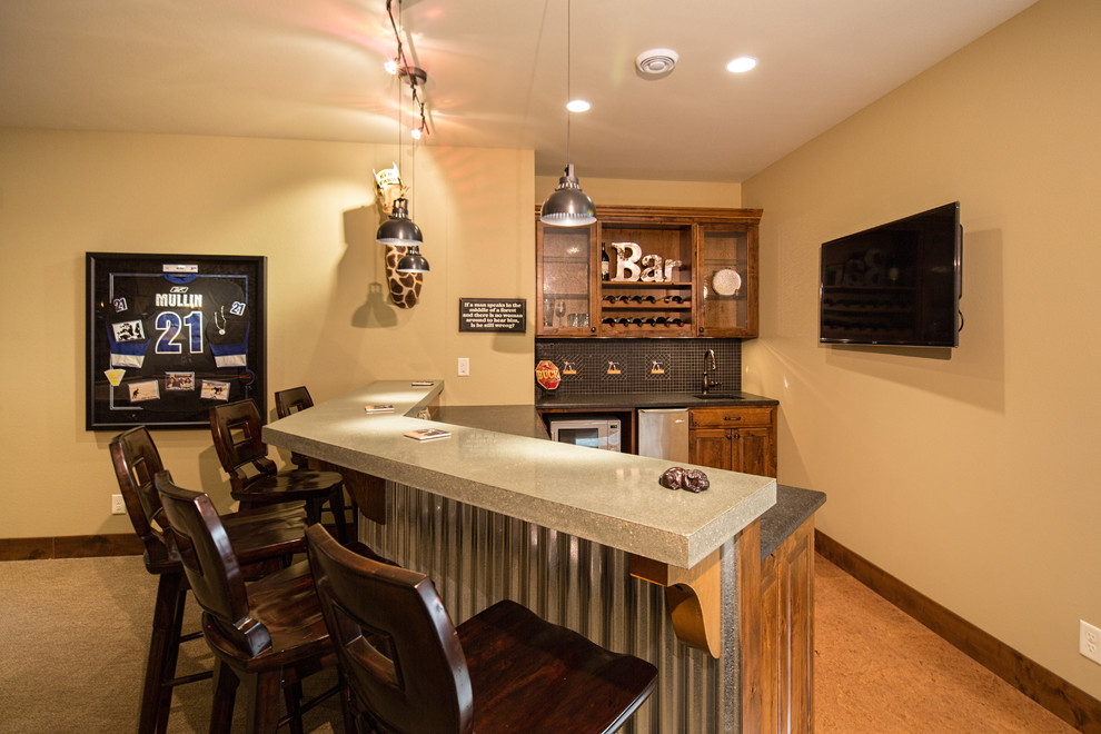 Photo of a mid-sized industrial wet bar in Other with an undermount sink, dark wood cabinets, concrete benchtops, carpet and raised-panel cabinets.
