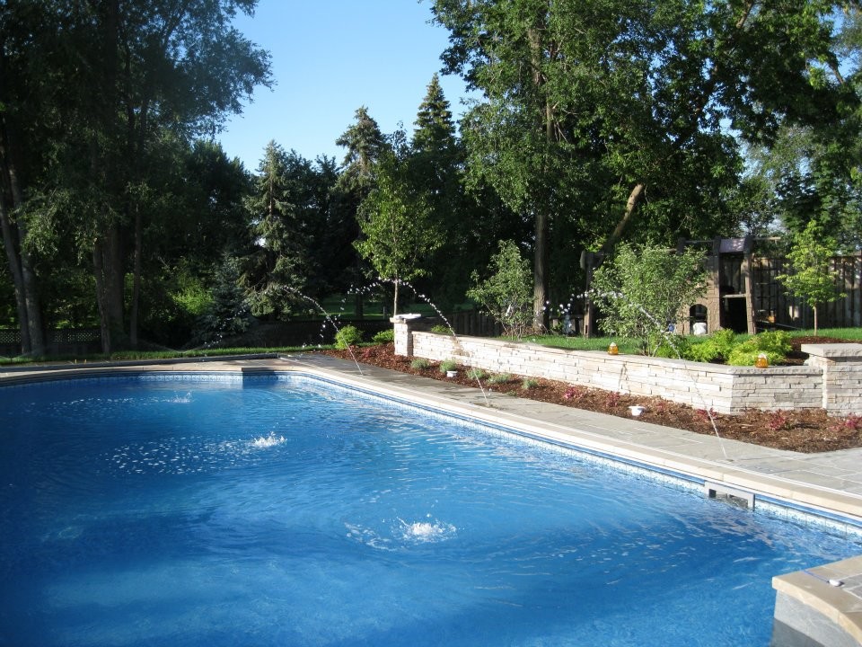 Inspiration for a large backyard stone pool remodel in Toronto