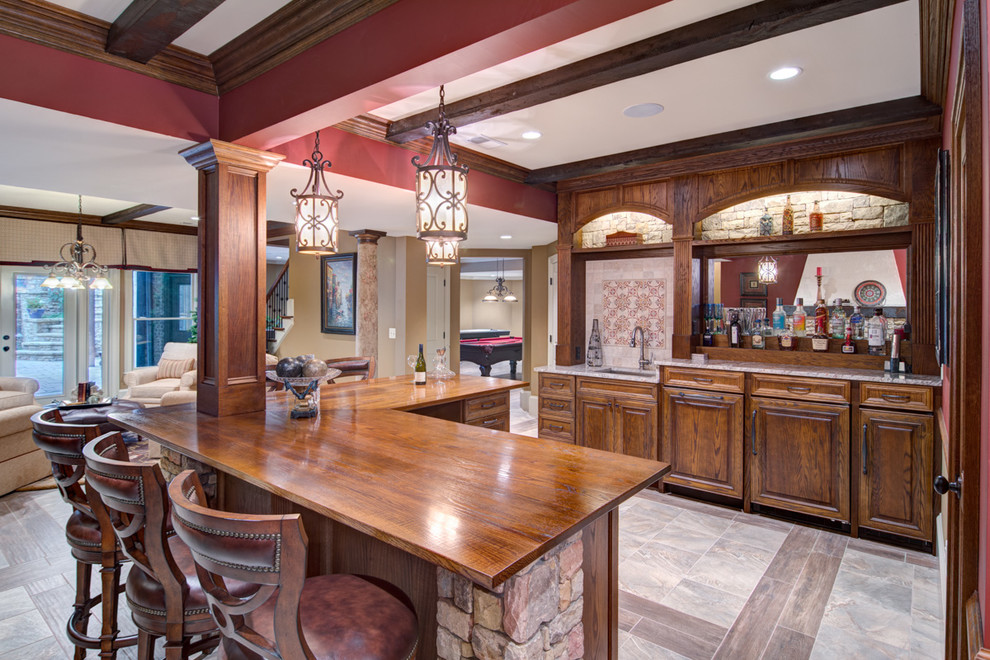 Design ideas for a large traditional l-shaped seated home bar in Atlanta with porcelain floors, an undermount sink, raised-panel cabinets, dark wood cabinets and mirror splashback.