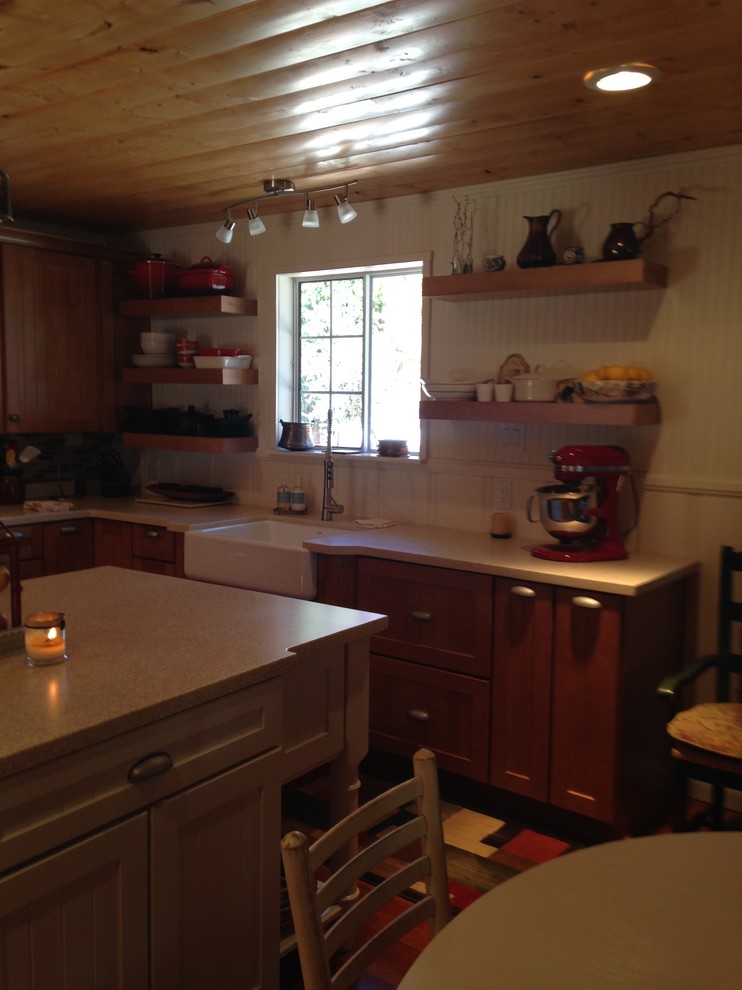 Open concept kitchen - mid-sized rustic l-shaped medium tone wood floor open concept kitchen idea with a farmhouse sink, beaded inset cabinets, light wood cabinets, solid surface countertops, beige backsplash, glass tile backsplash, stainless steel appliances and an island
