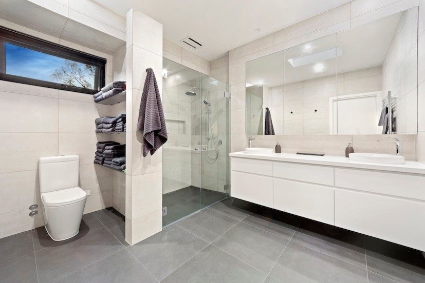 Inspiration for a contemporary master bathroom in Melbourne with beige walls, ceramic floors, white cabinets, a curbless shower, a one-piece toilet, gray tile, a vessel sink and marble benchtops.
