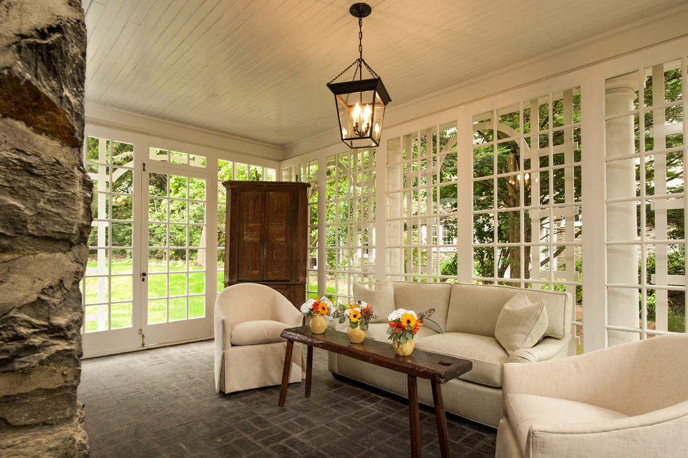 Inspiration for a mid-sized traditional sunroom in Philadelphia with a standard ceiling, brick floors, grey floor, a standard fireplace and a stone fireplace surround.