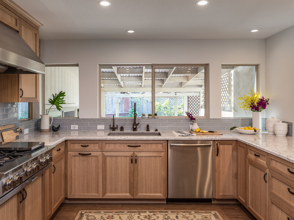 Inspiration for a mid-sized transitional eat-in kitchen in San Francisco with light wood cabinets, quartzite benchtops, blue splashback, stainless steel appliances, light hardwood floors, brown floor, grey benchtop and a peninsula.