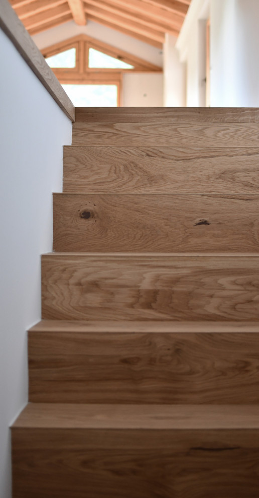 Contemporary wood l-shaped wood railing staircase in Other with wood risers.