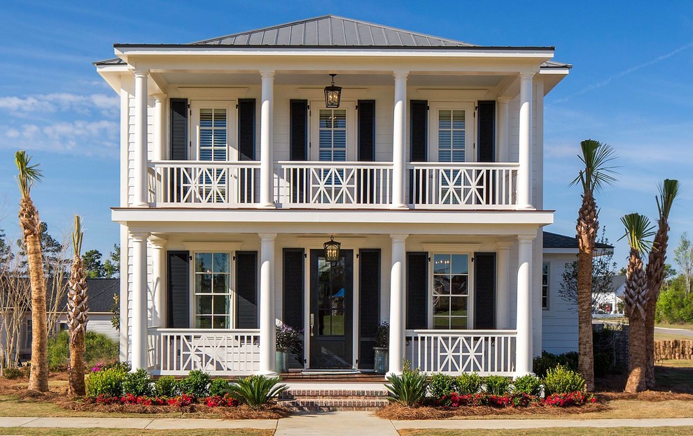 Beach style two-storey white house exterior in Atlanta with a hip roof and a metal roof.