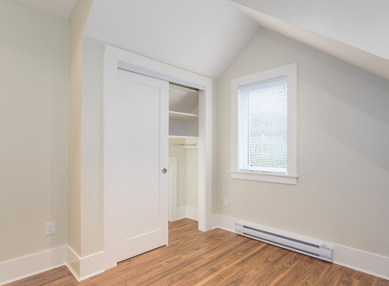 Mid-sized transitional gender-neutral built-in wardrobe in Vancouver with medium hardwood floors and brown floor.