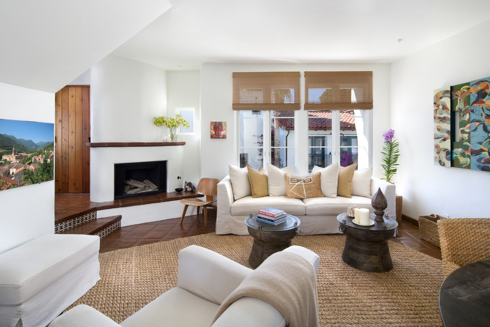 Photo of a mid-sized mediterranean formal open concept living room in Santa Barbara with white walls, terra-cotta floors, a corner fireplace and a plaster fireplace surround.