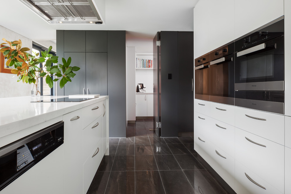Photo of a modern kitchen in Perth with flat-panel cabinets, white cabinets, quartz benchtops, stainless steel appliances, with island and white benchtop.