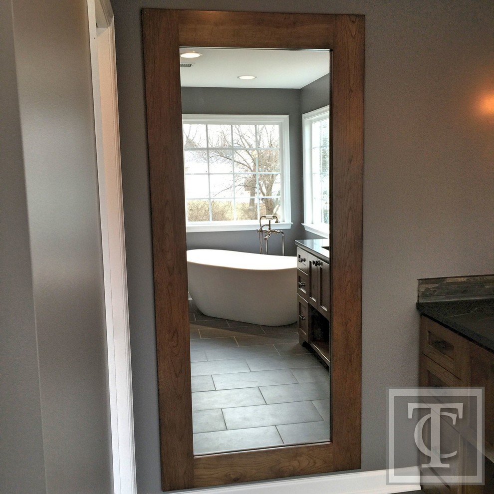 Design ideas for a mid-sized country master bathroom in Baltimore with an undermount sink, shaker cabinets, medium wood cabinets, soapstone benchtops, a freestanding tub, a double shower, a two-piece toilet, gray tile, stone tile, grey walls and porcelain floors.
