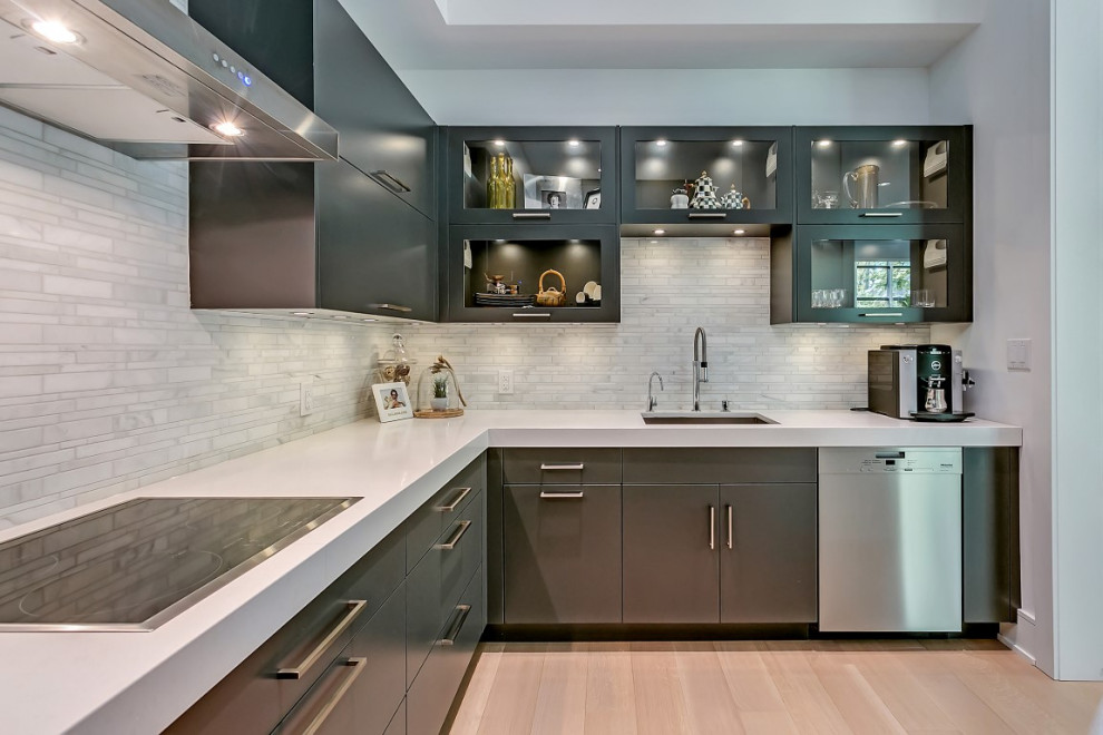 Large transitional l-shaped light wood floor open concept kitchen photo in Toronto with an undermount sink, flat-panel cabinets, gray cabinets, quartzite countertops, white backsplash, porcelain backsplash, stainless steel appliances, an island and white countertops