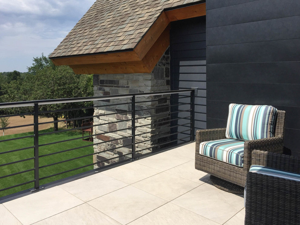 Example of a large transitional backyard deck design with a roof extension