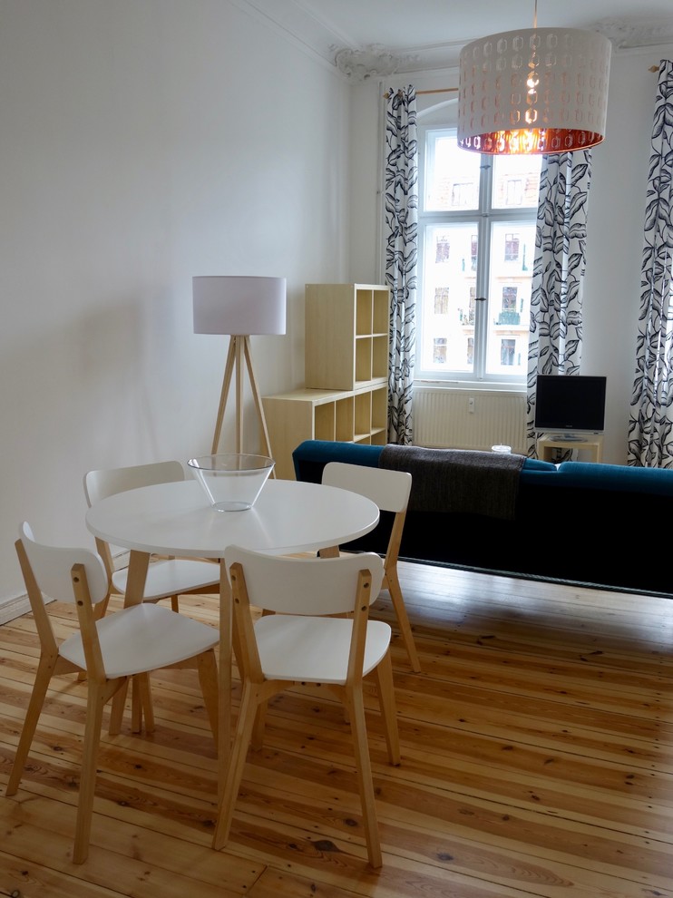 Kleines Skandinavisches Esszimmer ohne Kamin mit weißer Wandfarbe, braunem Holzboden und braunem Boden in Berlin