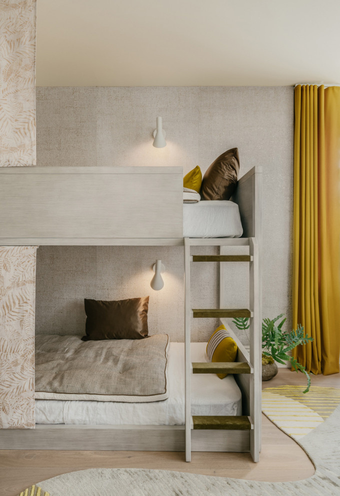 Inredning av ett nordiskt mellanstort könsneutralt barnrum kombinerat med sovrum, med beige väggar, ljust trägolv och beiget golv