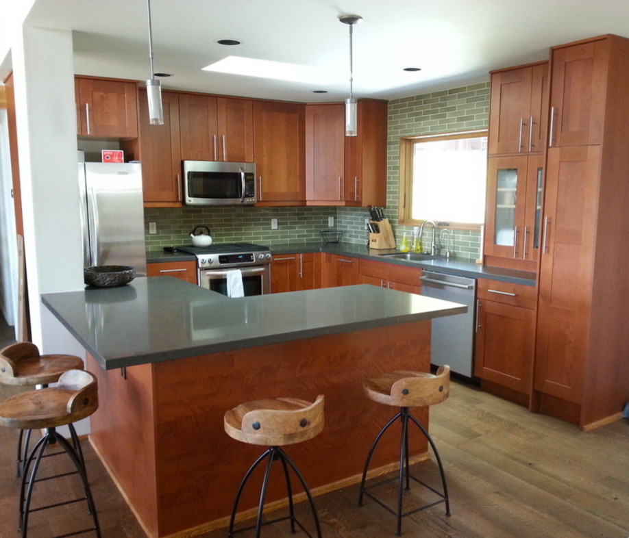 Example of a mid-sized transitional l-shaped light wood floor and brown floor eat-in kitchen design in Sacramento with an undermount sink, shaker cabinets, medium tone wood cabinets, granite countertops, green backsplash, subway tile backsplash, stainless steel appliances and an island