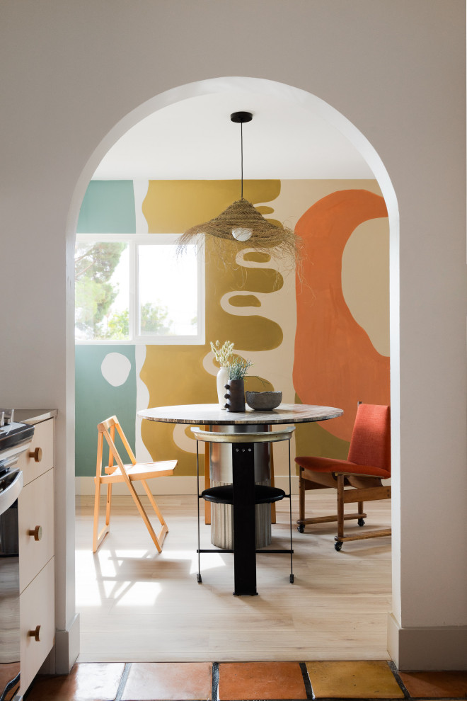 Idée de décoration pour une salle à manger vintage fermée avec un mur multicolore, parquet clair, un sol beige et du papier peint.
