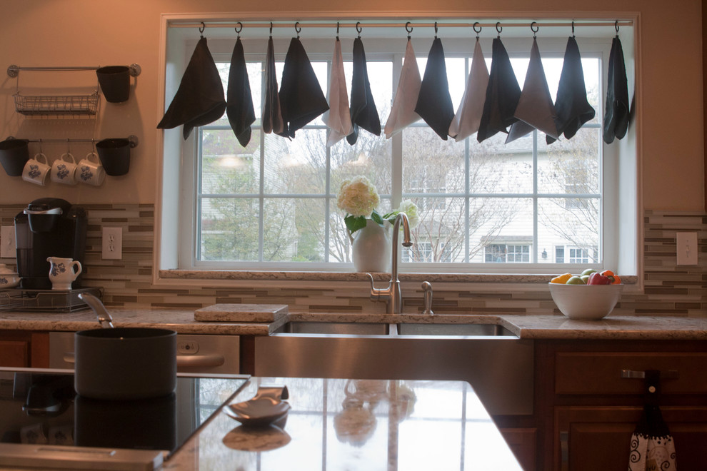 Example of a mid-sized transitional l-shaped medium tone wood floor open concept kitchen design in DC Metro with a double-bowl sink, raised-panel cabinets, medium tone wood cabinets, granite countertops, brown backsplash, stainless steel appliances and an island