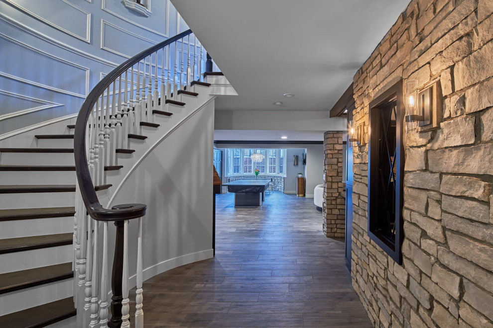 Idée de décoration pour un grand sous-sol design enterré avec un bar de salon, un mur blanc, parquet clair, une cheminée standard, un manteau de cheminée en bois et un sol gris.