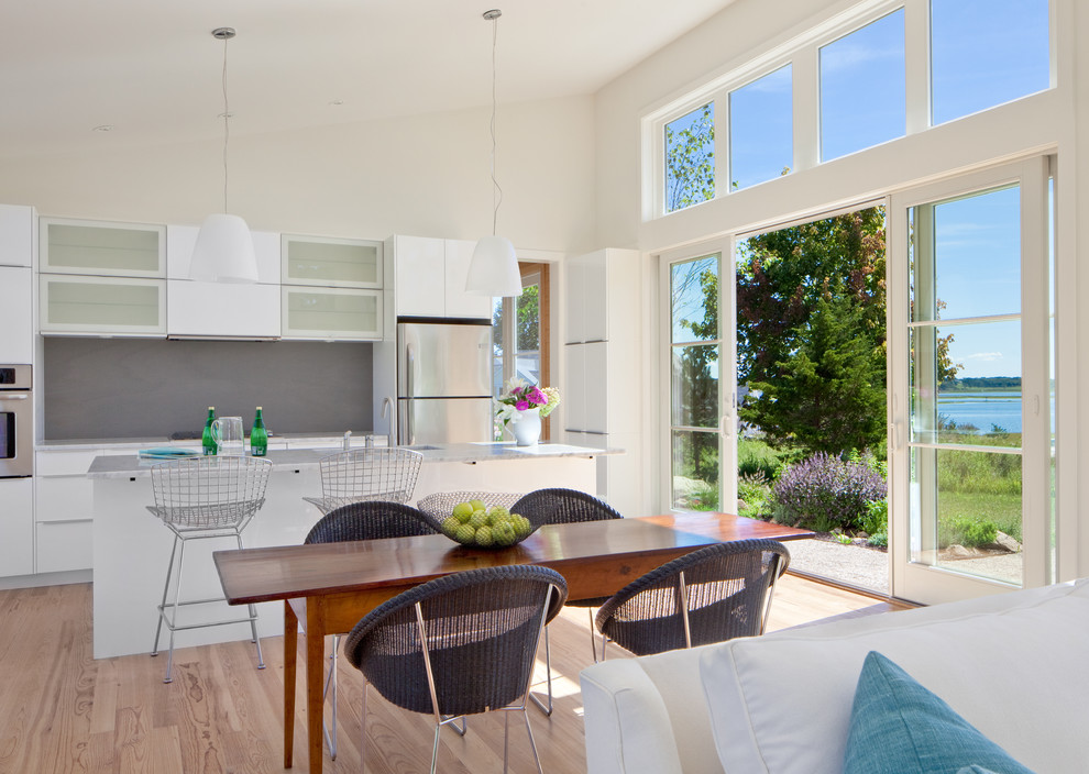 Inspiration for a beach style open plan dining in Providence with white walls and light hardwood floors.