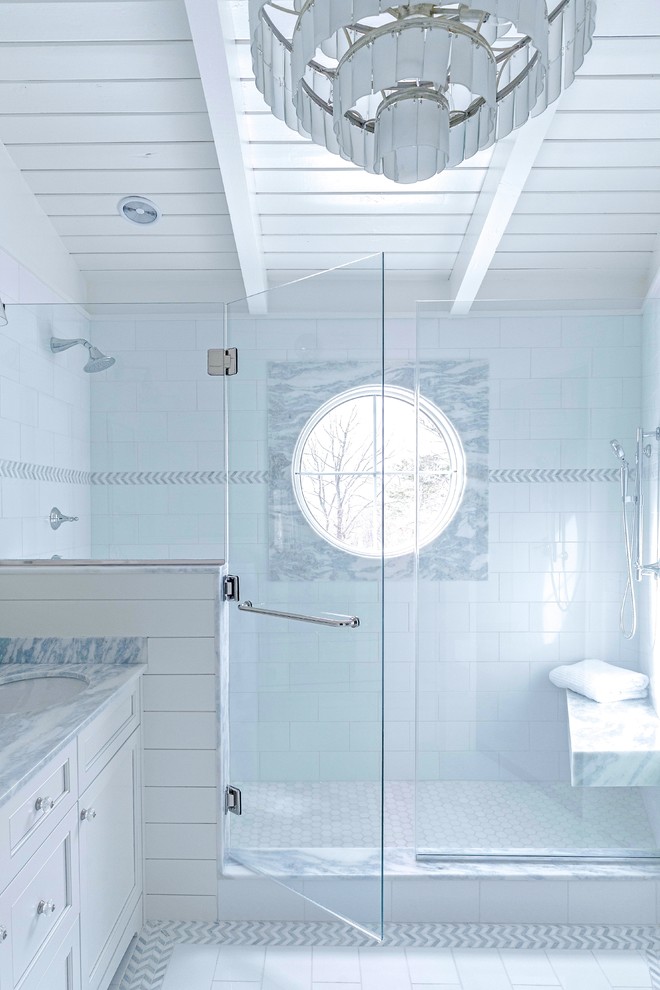 Photo of a mid-sized transitional master bathroom in Boston with flat-panel cabinets, white cabinets, an open shower, a two-piece toilet, white tile, porcelain tile, white walls, porcelain floors, an undermount sink, marble benchtops, white floor, a hinged shower door and blue benchtops.