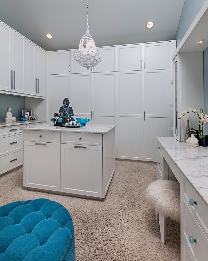 Large contemporary women's dressing room in Detroit with white cabinets, carpet, shaker cabinets and beige floor.