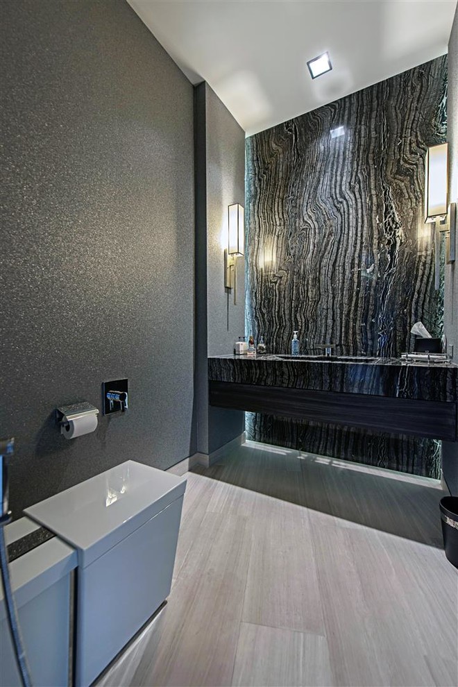 Mid-sized modern 3/4 bathroom in Las Vegas with a one-piece toilet, black and white tile, stone slab, grey walls, porcelain floors, an integrated sink, zinc benchtops and grey floor.