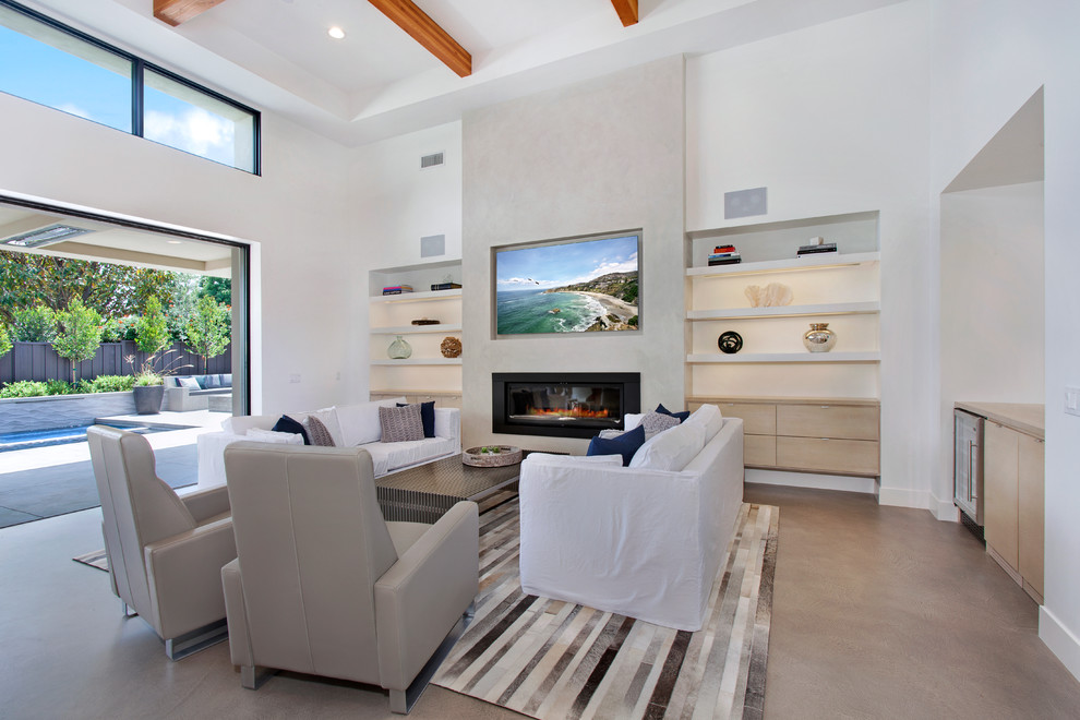 Mid-sized contemporary open concept living room in Orange County with a home bar, beige walls, concrete floors, a standard fireplace, a plaster fireplace surround and a built-in media wall.