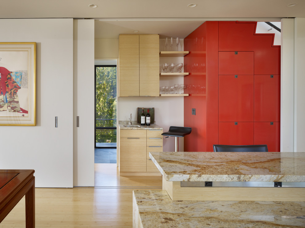 Photo of a mid-sized modern single-wall open plan kitchen in Seattle with flat-panel cabinets, granite benchtops, light wood cabinets, with island, an undermount sink and bamboo floors.