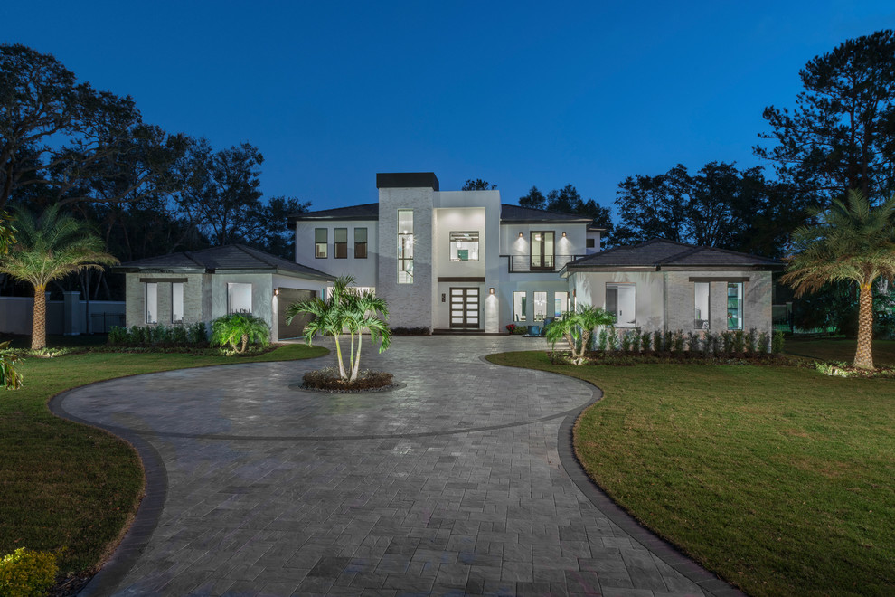 Large contemporary two-storey stucco white house exterior in Orlando with a flat roof and a tile roof.