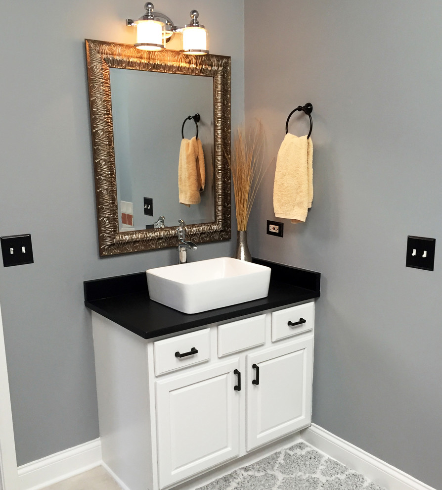 Mid-sized transitional master gray tile and ceramic tile ceramic tile corner bathtub photo in Chicago with raised-panel cabinets, black cabinets, a one-piece toilet, gray walls, a vessel sink and granite countertops