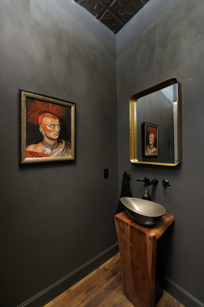 This is an example of an eclectic powder room in St Louis with grey walls, medium hardwood floors, a vessel sink and brown floor.