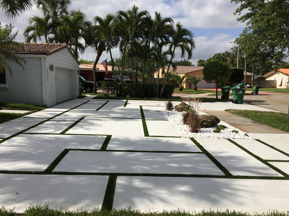This is an example of a mid-sized contemporary partial sun front yard concrete paver driveway in Miami.