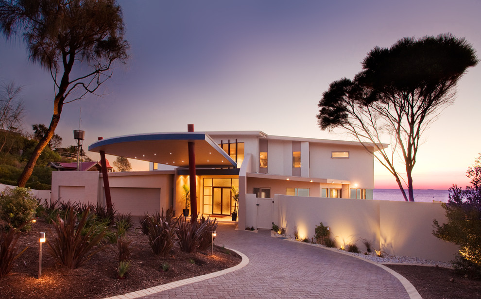 Photo of a large beach style two-storey stucco white exterior in Melbourne.