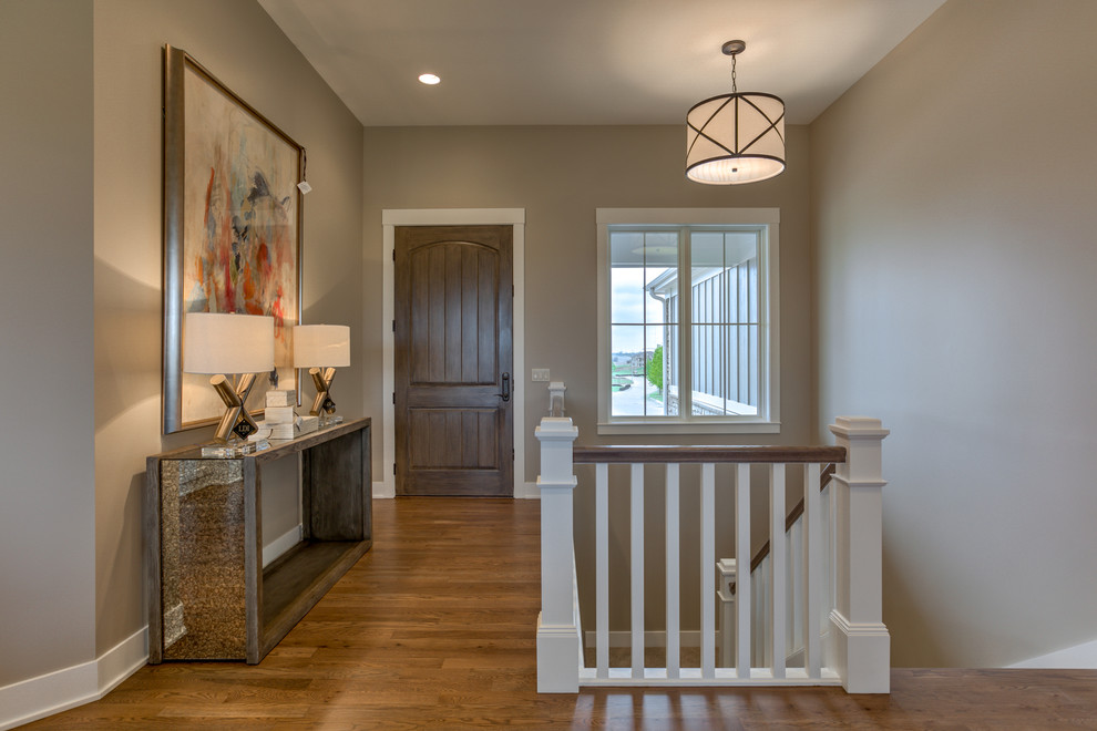 Inspiration for a mid-sized transitional medium tone wood floor and beige floor front door remodel in Omaha with beige walls and a dark wood front door