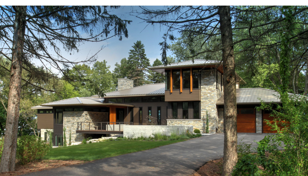Diseño de fachada de casa gris y gris minimalista de tres plantas con revestimiento de piedra, tejado a cuatro aguas, tejado de metal y tablilla