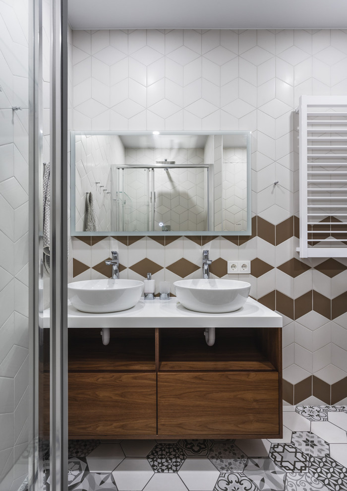 Mid-sized contemporary kids bathroom in Moscow with flat-panel cabinets, medium wood cabinets, an alcove shower, a wall-mount toilet, white tile, ceramic tile, white walls, ceramic floors, a drop-in sink, solid surface benchtops, grey floor, a sliding shower screen and white benchtops.