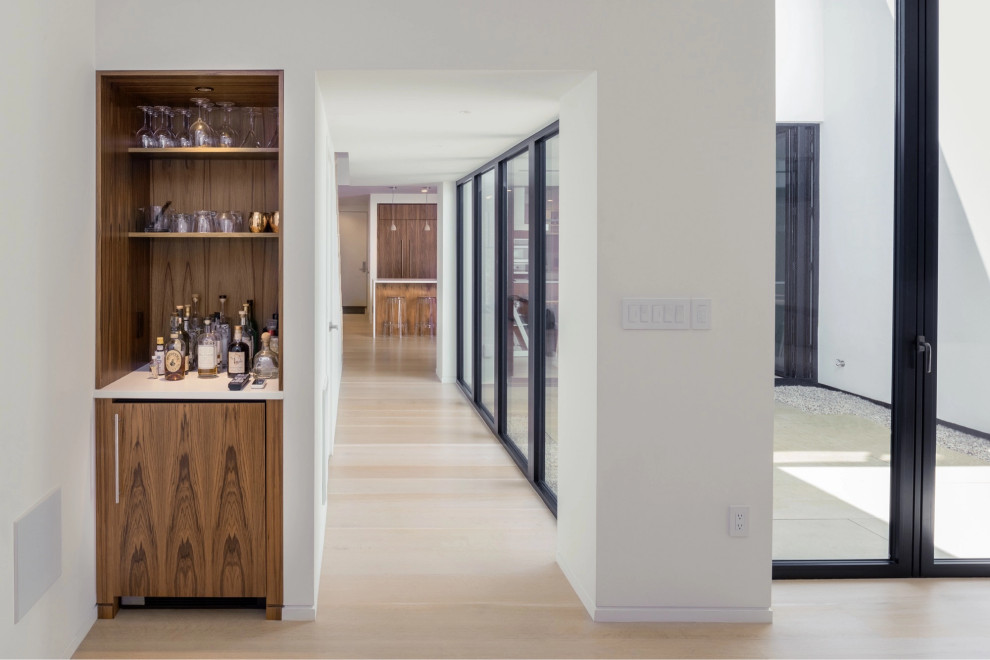Photo of a contemporary hallway in Boston with light hardwood floors.