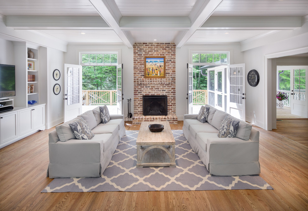 Design ideas for a large transitional open concept living room in Atlanta with grey walls, medium hardwood floors, a standard fireplace, a brick fireplace surround, a wall-mounted tv and brown floor.
