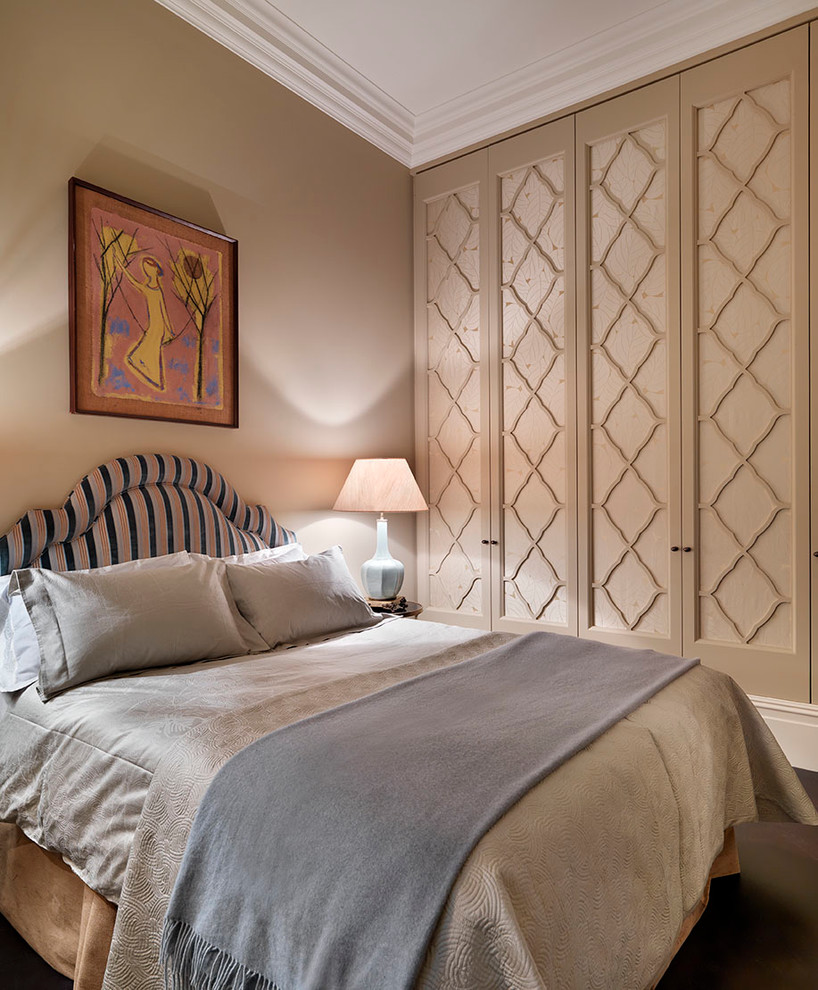 This is an example of a large traditional guest bedroom in London with beige walls and carpet.