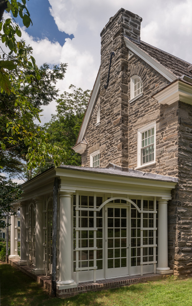 Photo of a mid-sized traditional three-storey grey exterior in Philadelphia with stone veneer and a gable roof.