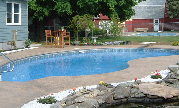Inspiration for a large backyard stone and custom-shaped pool remodel in Boston